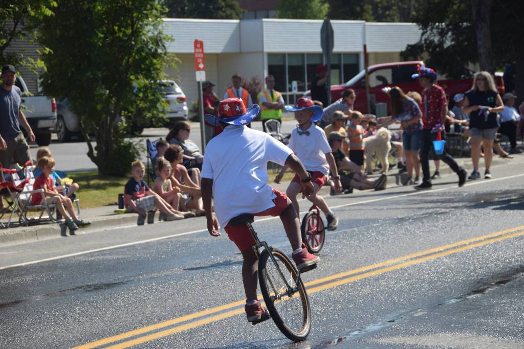Kids show off their unicycle skills during the July 4th parade in Kenai, Alaska. (Photo by Brian Mazurek/Peninsula Clarion)