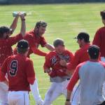 Peninsula Oilers outfielder Paul Steffensen (center) is mobbed by teammates after delivering the game-winning play Sunday, July 7, 2019, against the Mat-Su Miners at Coral Seymour Memorial Park in Kenai, Alaska. (Photo by Joey Klecka/Peninsula Clarion)