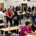 In this July 10, 2019, photo provided by Rochelle Adams, the mayor of Wasilla, Alaska, Bert Cottle, center left in the orange shirt, is seen grabbing the arm of Alaska Native activist Haliehana Stepetin, who was trying to take part in a sit-in of legislators meeting in Wasilla. Stepetin filed an assault complaint with the Wasilla Police Department on Thursday, naming Cottle and Zachary Freeman, the spokesman for the Republican House Minority, seen next to Cottle in the white dress shirt. (Rochelle Adams via AP)