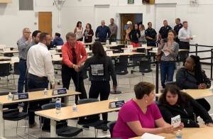 In this July 10, 2019, photo provided by Rochelle Adams, the mayor of Wasilla, Alaska, Bert Cottle, center left in the orange shirt, is seen grabbing the arm of Alaska Native activist Haliehana Stepetin, who was trying to take part in a sit-in of legislators meeting in Wasilla. Stepetin filed an assault complaint with the Wasilla Police Department on Thursday, naming Cottle and Zachary Freeman, the spokesman for the Republican House Minority, seen next to Cottle in the white dress shirt. (Rochelle Adams via AP)
