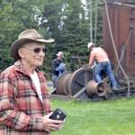 Dr. Peter Hansen stands in front of crane operators who are in the process of lifting an antique steam donkey engine at the Kenai Visitor and Cultural Center, where it will be relocated on the lawn to make room for a cabin that will act as a Kenai Bush doctors museum, Monday, July 15, 2019, in Kenai, Alaska. (Photo by Victoria Petersen/Peninsula Clarion)