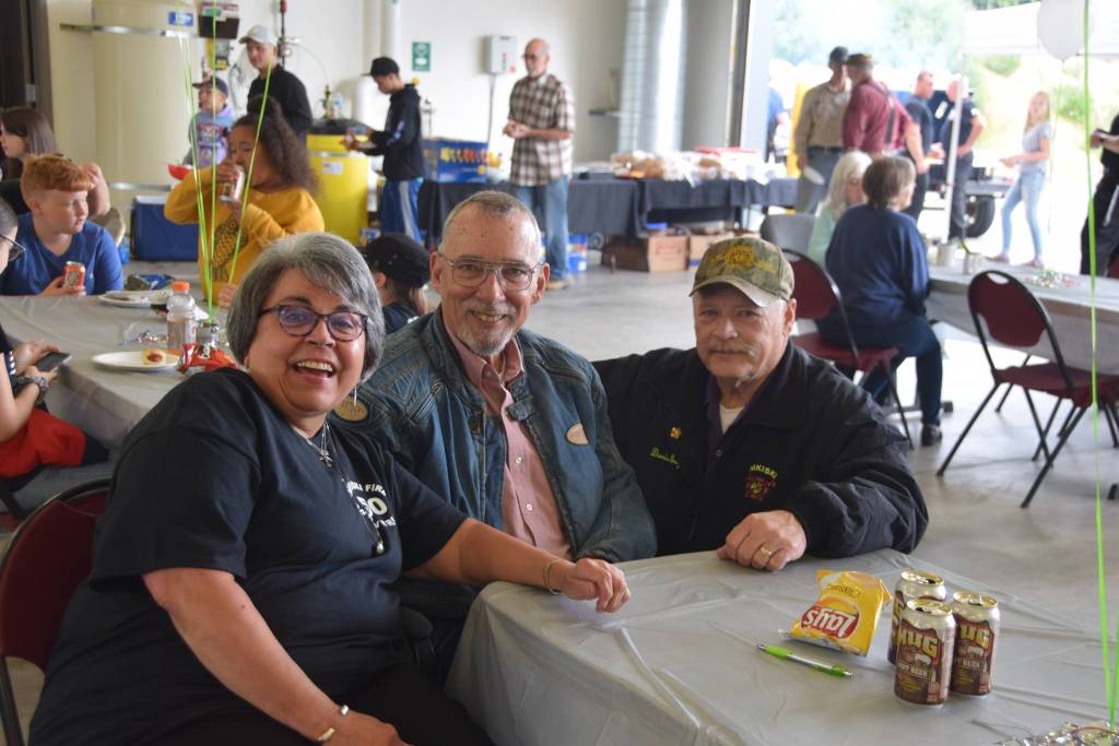 From left, Terry Carter, Dave Unruh, and Dan Gregory smile for the camera at Fire Station #2 during the Nikiski Fire Departments 50th anniversary celebration in Nikiski, Alaska on July 15, 2019. Carter has been the front desk receptionist for the department for 30 years. Unruh is a retired captain and was the second person employed by the department, and Gregory was was fire chief from 2000 to 2005. (Photo by Brian Mazurek/Peninsula Clarion)