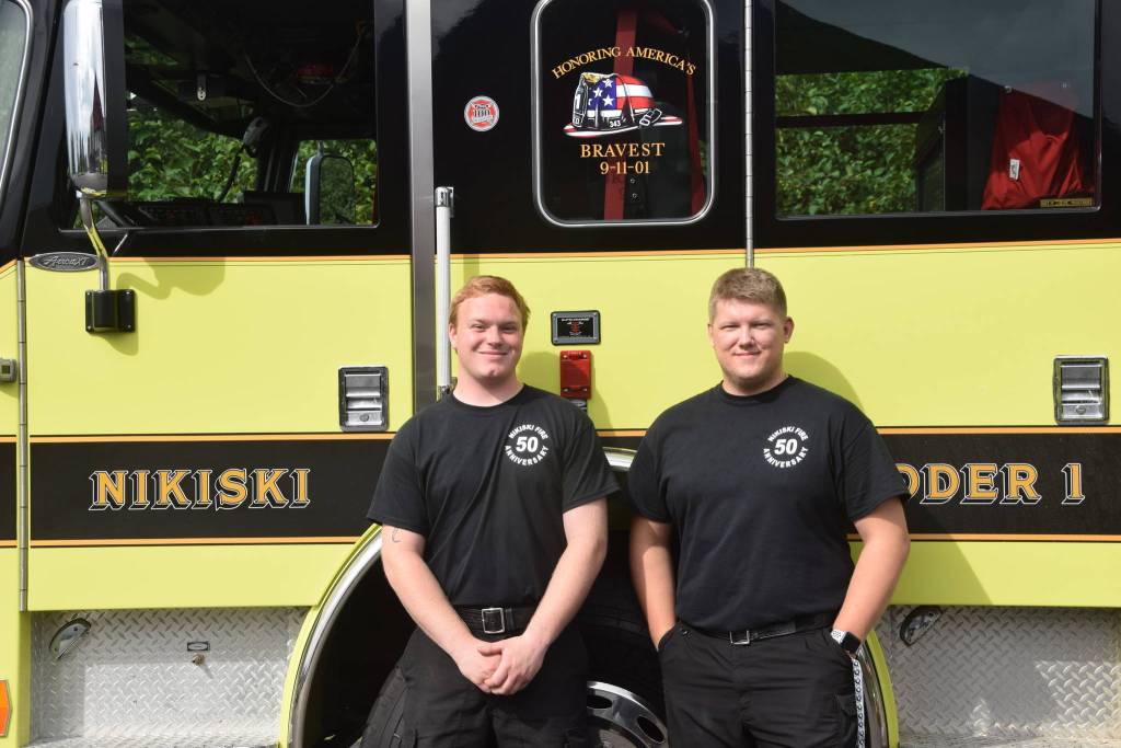 Volunteers Brandon Edwards, left, and Vlad Glushkov, right, smile for the camera at Fire Station #2 during the Nikiski Fire Departments 50th anniversary celebration in Nikiski, Alaska on July 15, 2019. (Photo by Brian Mazurek/Peninsula Clarion)