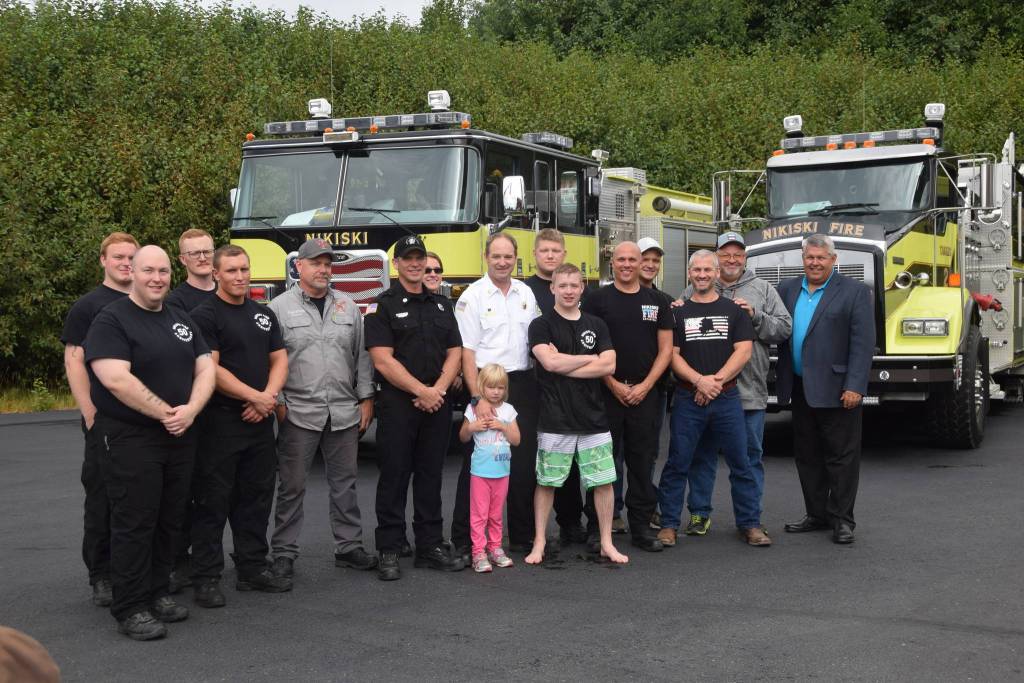 Current and former personnel for the Nikiski Fire Department smile for the camera at Fire Station #2 during the departments 50th anniversary celebration in Nikiski, Alaska on July 15, 2019. (Photo by Brian Mazurek/Peninsula Clarion)