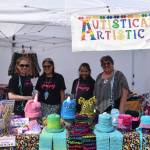 From left, Jennifer Pelka, Cece Strongheart, Glenna Strongheart and Ann Strongheart pose for a photo at their vendor booth during the 2019 Disability Pride Celebration in Soldotna Creek Park on July 20, 2019. Cece, who is autistic, knits hats and makes various crafts to sell such as bookmarks and stickers. (Photo by Brian Mazurek/Peninsula Clarion)