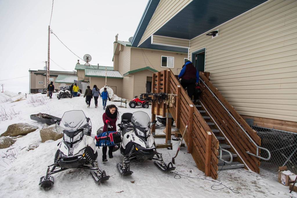 Nuulau Alaelua, a senior at East Anchorage High School, carries her bags into a district-owned apartment in Scammon Bay where she and some of her fellow students and teacher will stay for four days.