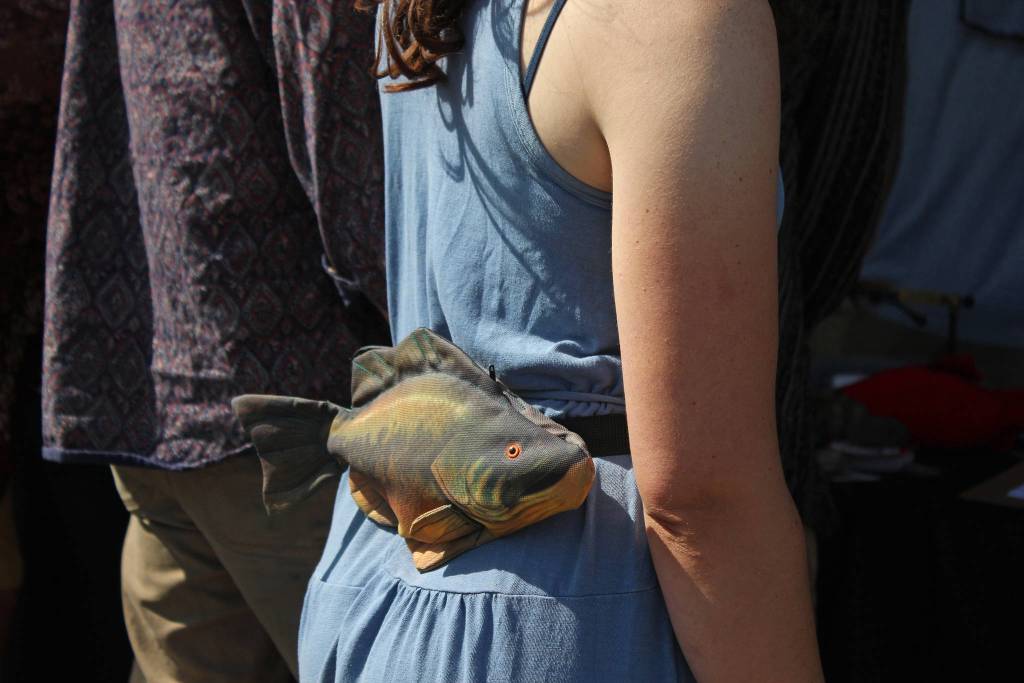 A woman walks through the Ninilchik Fairgrounds with a salmon fanny pack on Friday, Aug. 2, 2019 at Salmonfest in Ninilchik, Alaska. (Photo by Megan Pacer/Homer News)
