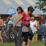 Women dance in the grass during a performance at the Ocean Stage on Friday, Aug. 2, 2019 at Salmonfest in Ninilchik, Alaska. (Photo by Megan Pacer/Homer News)