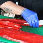 Evan Vogl, chef at the Little Mermaid in Homer, prepares salmon for a poke during a food demonstration on Friday, Aug. 2, 2019 at Salmonfest in Ninilchik, Alaska. The chef at the festival food demos are a take on the chef at the market that happens at the Homer Farmers Market. (Photo by Megan Pacer/Homer News)