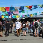 Festival goers walk through the Salmon Causeway  the collection of education and advocacy booths  on Friday, Aug. 2, 2019 at Salmonfest in Ninilchik, Alaska. (Photo by Megan Pacer/Homer News)