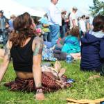 A woman relaxes in the grass while listening to a performance at the Ocean Stage at this years Salmonfest on Friday, Aug. 2, 2019 in Ninilchik, Alaska. (Photo by Megan Pacer/Homer News)