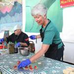 Margarida Kondak lays out salmon poke for festival goers to try during a chef at the festival food demonstration Friday, Aug. 2, 2019 at Salmonfest in Ninilchik, Alaska. (Photo by Megan Pacer/Homer News)