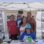 From left, Michele Vasquez, Eric Trieder, Fay Herold, Nelma Treider and Karyn Griffin smile for a photo while collecting signatures to recall Governor Mike Dunleavy in Soldotna Creek Park on Aug. 7, 2019. (Photo by Brian Mazurek/Peninsula Clarion)