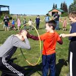 Kids attempt to travel through a space portal, also known as a hula hoop, during the last day of the Kenai Community Librarys summer reading program at the Kenai Park Strip on August 8, 2019. (Photo by Brian Mazurek/Peninsula Clarion)