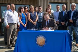 Gov. Mike Dunleavy signs SB 2002 at the Alaska Association of General Contractors in Anchorage on Thursday, Aug. 8, 2019. (Courtesy photo)