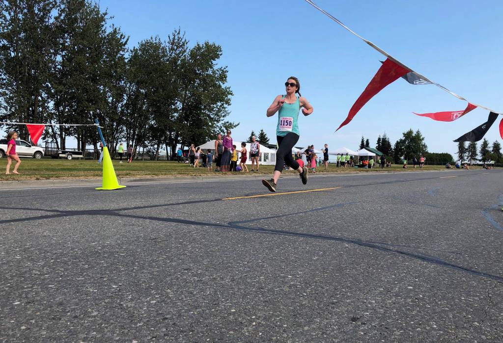 Womens 10-kilometer winner Jenny Rutledge crossed the finish line Saturday, Aug. 10, 2019, at the 32nd annual Run for Women in Kenai, Alaska. (Photo by Joey Klecka/Peninsula Clarion)