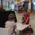 Mason Clark, left, and Bridger Clark, right, practice their art skills at the Frontier Community Services booth during KidFest at the Peninsula Center Mall in Soldotna, Alaska on Aug. 10, 2019. (Photo by Brian Mazurek/Peninsula Clarion)