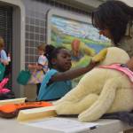 Chief Animal Control Officer Jessica Hendrickson, right, teaches Angelica Youngberg about proper animal care at the Kenai Animal Shelter Booth during KidFest at the Peninsula Center Mall in Soldotna, Alaska on Aug. 10, 2019. (Photo by Brian Mazurek/Peninsula Clarion)