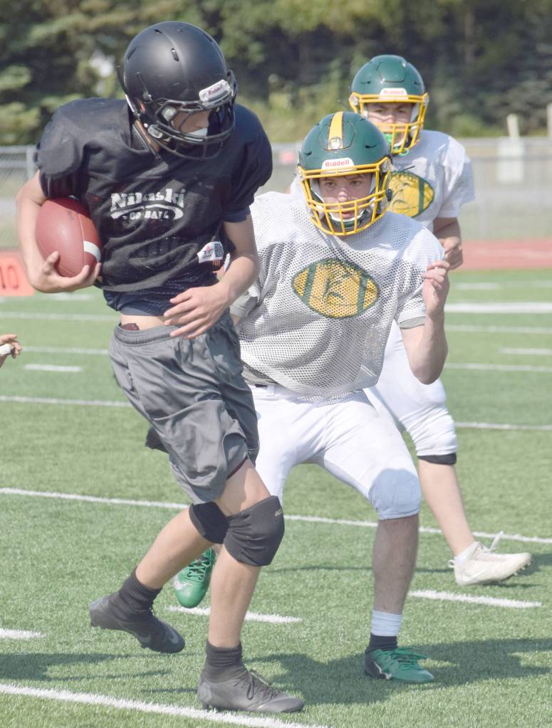 Nikiskis Mason Payne runs against Sewards Steven Harshman in a scrimmage Saturday, Aug. 10, 2019, at Ed Hollier Field in Kenai, Alaska. (Photo by Jeff Helminiak/Peninsula Clarion)