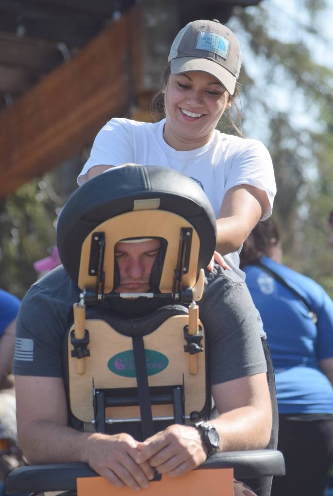 Maverick Boyer of Kenai makes a $5 donation to get a massage from Logan Simons of Boreal Massage after the Brewery to Bathroom .5K The race for the rest of us on Sunday, Aug. 11, 2019, in Soldotna, Alaska. (Photo by Jeff Helminiak/Peninsula Clarion)