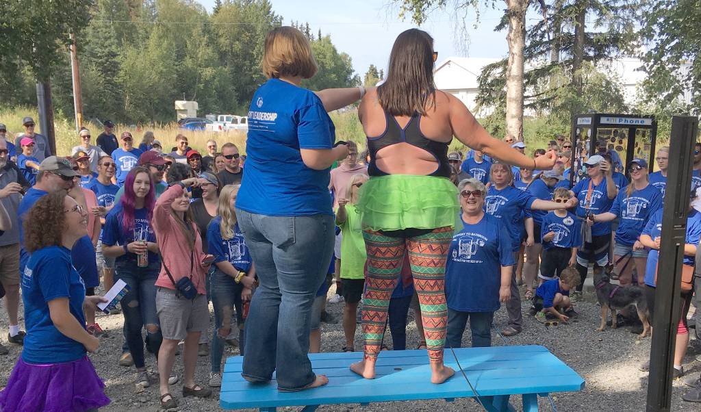 Johna Beech and Nicole Murphy warm up runners before the Brewery to Bathroom .5K The race for the rest of us on Sunday, Aug. 11, 2019, in Soldotna, Alaska. (Photo by Jeff Helminiak/Peninsula Clarion)