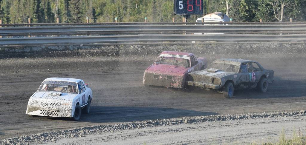 Mady Stichal (second from right) bangs doors with Grace Bass Saturday, Aug. 10, 2019, at Twin City Raceway in Kenai, Alaska. (Photo by Joey Klecka/Peninsula Clarion)