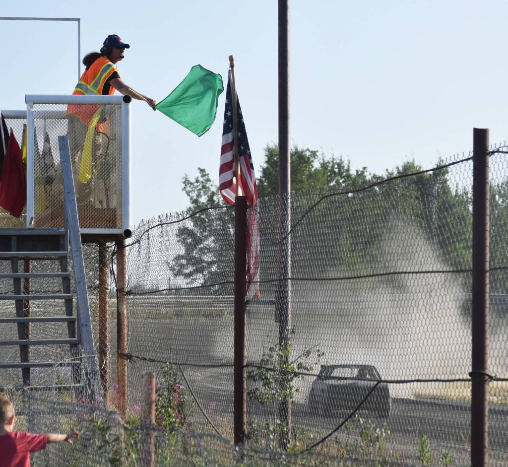 The flagman waves the green flag Saturday, Aug. 10, 2019, at Twin City Raceway in Kenai, Alaska. (Photo by Joey Klecka/Peninsula Clarion)