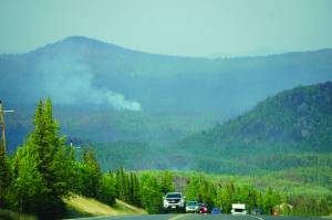 A plume of smoke rises from the Swan Lake fire area as vehicles head south on the Sterling Highway on July 18, 2019, near Skilak Lake, Alaska. (Photo by Michael Armstrong/Homer News)