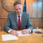 Gov. Mike Dunleavy signs House Bill 2001 at his office in Anchorage on Monday, August 19, 2019. (Courtesy photo)