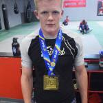 Soldotnas Sean Babitt stands with his first-place medal Thursday at Redemption MMA. Babitt won a division title at the IBJJF World Championships June 1 in Long Beach, California. (Photo by Joey Klecka/Peninsula Clarion)