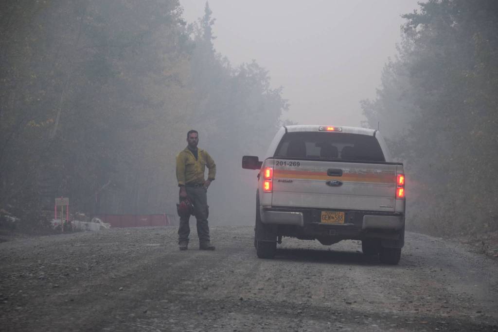 A firefighter can be seen here discussing the days operations on Skilak Lake Road southeast of Sterling, Alaska on Aug. 30, 2019. (Photo by Brian Mazurek/Peninsula Clarion)
