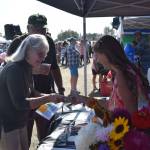 Anna Devolld, right, presents her Promote Our Pollinators project to attendees of Industry Appreciation Day at the Kenai Park Strip in Kenai, Alaska on Aug. 24, 2019. (Photo by Brian Mazurek/Peninsula Clarion)