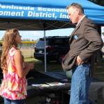 Anna Devolld speaks with Governor Mike Dunleavy about her Promote our Pollinators project at Industry Appreciation Day at the Kenai Park Strip in Kenai, Alaska on Aug. 24, 2019. (Photo courtesy Shona Devolld)