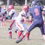 Kenais Zach Burnett takes a handoff from Kardinals quarterback Bridger Beck as Tucker Vann (32) gets in position and North Poles Alexander Melson (9) moves in during the fourth quarter of Saturdays Division II nonconference game at North Pole High School. (Photo by Danny Martin/Fairbanks Daily News-Miner)