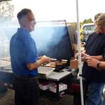 Sen. Peter Micciche, R-Soldotna, mans the grill with other volunteers during the first responder appreciation barbecue at Soldotna Creek Park on Monday, Sept. 9, 2019 in Soldotna, Alaska. (Photo by Brian Mazurek/Peninsula Clarion)