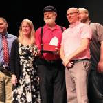 Former Alaska House Representative Paul Seaton (center) stands with members of the Kenai Peninsula Borough School District Board of Education and holds the golden apple award the board gave him at a Monday, Sept. 9, 2019 meeting at Homer High School in Homer, Alaska. (Photo by Megan Pacer/Homer News)