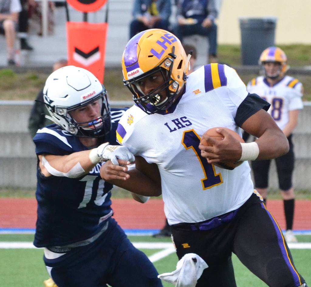 Lathrop quarterback Jace Henry (1) attempts to evade the tackle of Soldotnas Zach Hanson, Friday, Sept. 13, 2019, at Justin Maile Field in Soldotna, Alaska. (Photo by Joey Klecka/Peninsula Clarion)