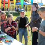 Kids make necklaces out of fresh vegetables at the Harvest Moon Local Food Festival at Soldotna Creek Park on Sept. 14, 2019. (Photo by Brian Mazurek/Peninsula Clarion)