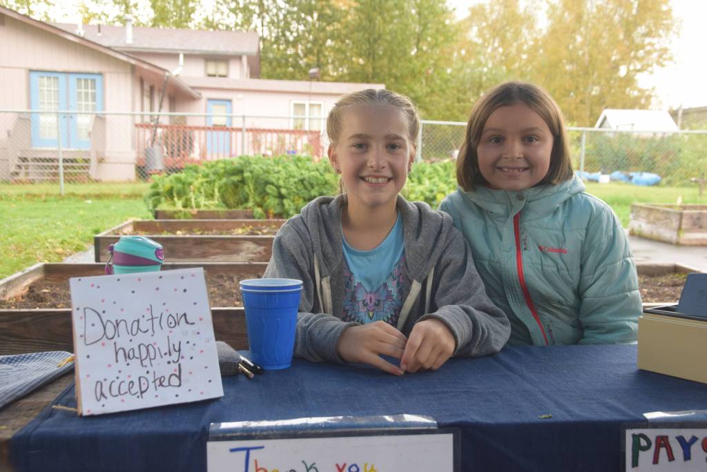Katie Debardelaben, left, and Aurora Oostman, right, hold down the cash register at the Montessori Farmers Market at the Soldotna Montessori School on Sept. 13, 2019. (Photo by Brian Mazurek/Peninsula Clarion)