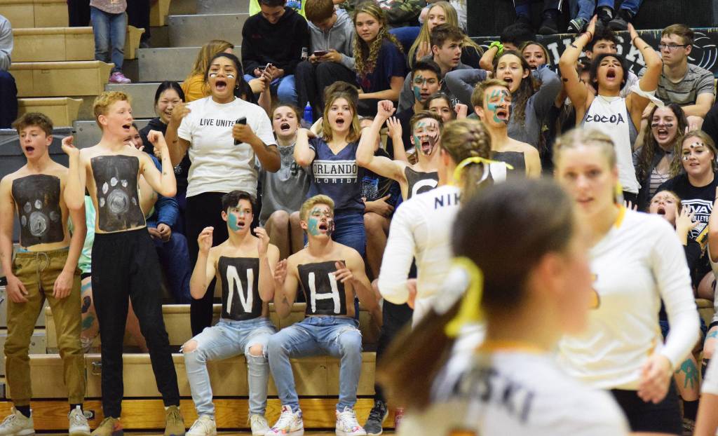 Nikiski High School students, as well as a few Soldotna High School volleyball players, cheer on the Nikiski volleyball team Tuesday, Sept. 17, 2019, against Kenai Central at Nikiski High School. (Photo by Joey Klecka/Peninsula Clarion)
