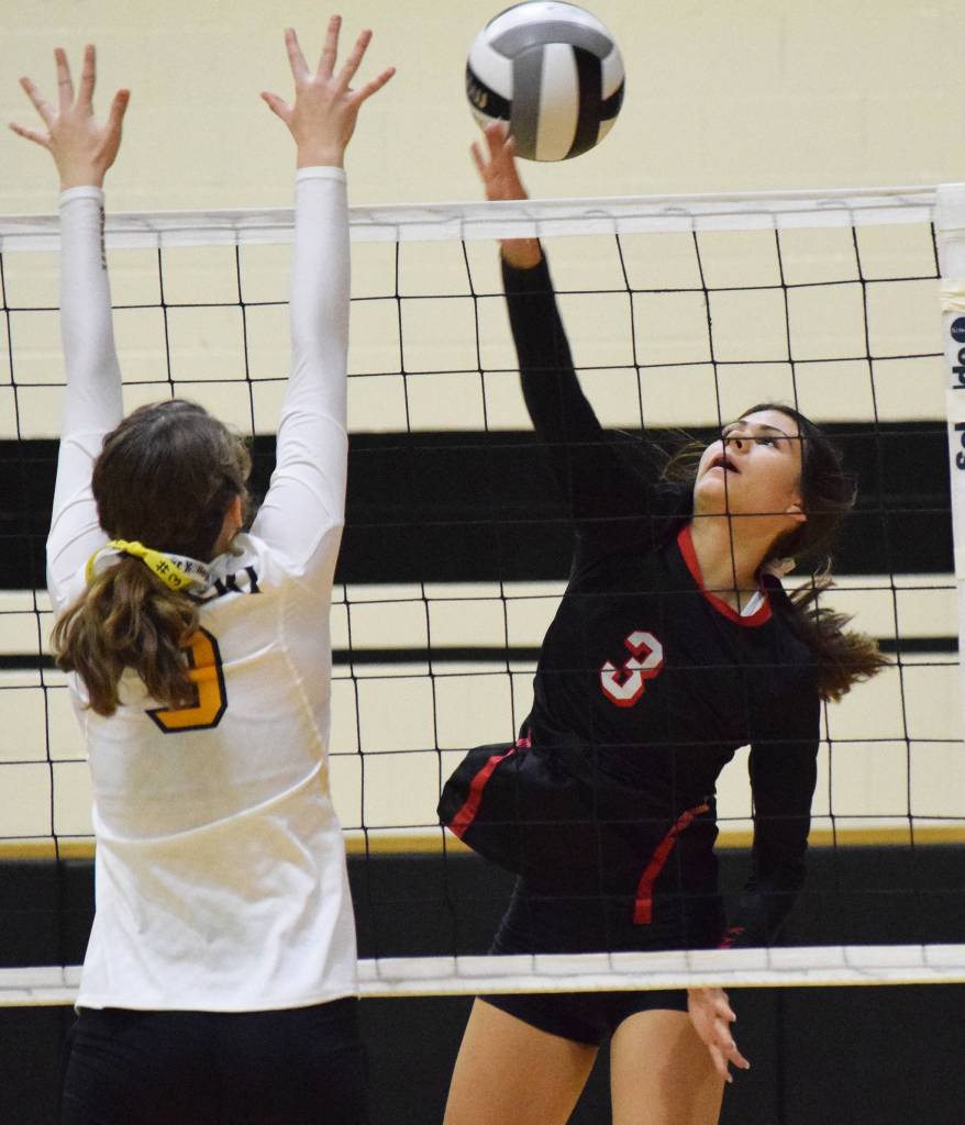 Kenai Central hitter Savanna Wilson (3) sends a shot over Nikiskis Jaycee Tauriainen, Tuesday, Sept. 17, 2019, at Nikiski High School. (Photo by Joey Klecka/Peninsula Clarion)