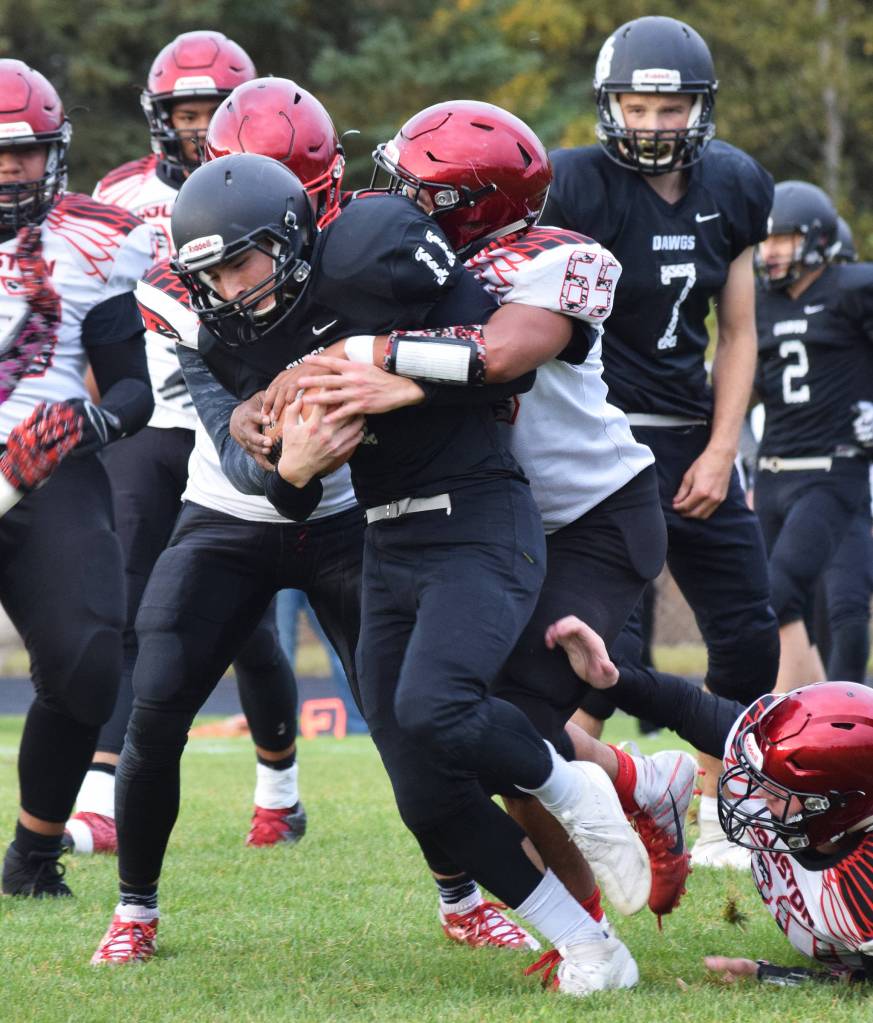 Nikiski running back Michael Mysing gets wrapped up by Houstons Brian Fialelei, Friday, Sept. 20, 2019, at Nikiski High School. (Photo by Joey Klecka/Peninsula Clarion)