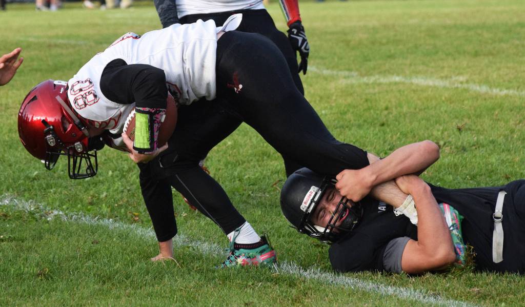 Houston quarterback Gavin Mulhaney attempts to shed the tackle of Nikiskis Caileb Payne, Friday, Sept. 20, 2019, at Nikiski High School. (Photo by Joey Klecka/Peninsula Clarion)