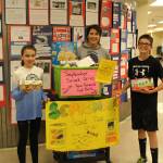 From left, eighth grader Avery Ciufo, student council adviser Sheilah Margaret Pothast and eighth grader Derrick Jones show off the food theyve collected during their snack drive at Skyview Middle School in Soldotna, Alaska on Sept. 20, 2019. (Photo by Brian Mazurek/Peninsula Clarion)