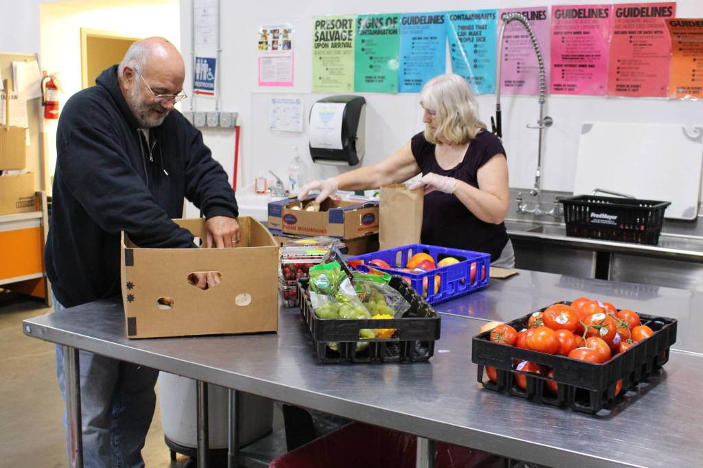 Food Bank volunteers Arnie Sullenger, left, and Mary Sullenger, right, sort produce at the Kenai Peninsula Food Bank in Soldotna, Alaska on Sept. 20, 2019. (Photo by Brian Mazurek/Peninsula Clarion)