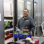 Food Bank employee Francis Bell stocks up the cooler at the Kenai Peninsula Food Bank in Soldotna, Alaska on Sept. 20, 2019. (Photo by Brian Mazurek/Peninsula Clarion)