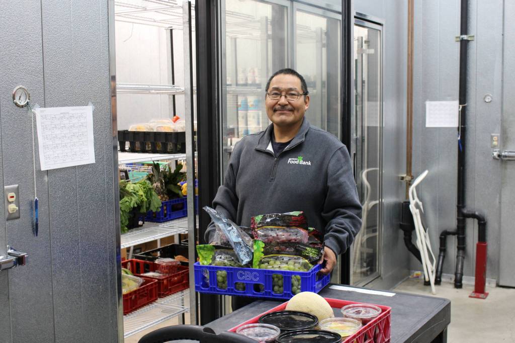 Food Bank employee Francis Bell stocks up the cooler at the Kenai Peninsula Food Bank in Soldotna, Alaska on Sept. 20, 2019. (Photo by Brian Mazurek/Peninsula Clarion)