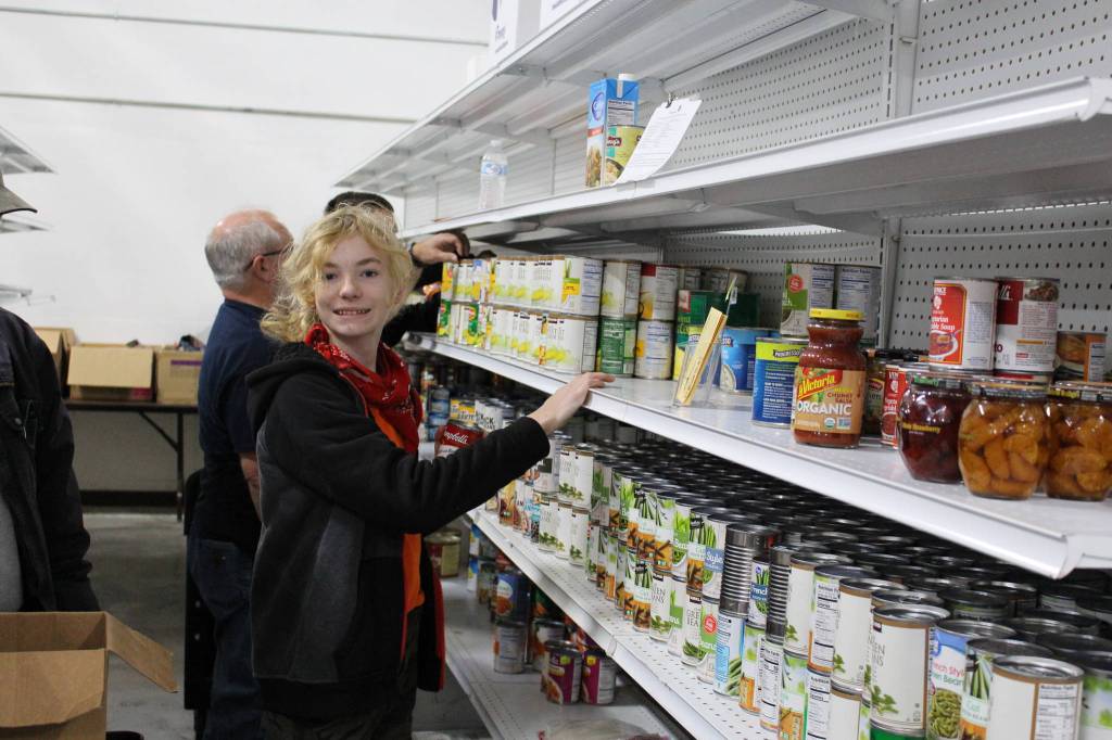 Food bank volunteer Gunnar Peters stocks the shelves at the Kenai Peninsula Food Bank in Soldotna, Alaska on Sept. 20, 2019. (Photo by Brian Mazurek/Peninsula Clarion)