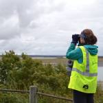 Alaska Wildlife Alliance member Grace Kautek looks out over the Kenai River for signs of belugas during the third annual Belugas Count! event at Erik Hansen Scout Park in Kenai, Alaska on Sept. 21, 2019. (Photo by Brian Mazurek)