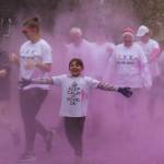 Brian Mazurek / Peninsula Clarion                                Participants in the 2019 Stomp Out Stigma Color Run make their way through a haze of pink chalk at Soldotna Creek Park on Saturday.